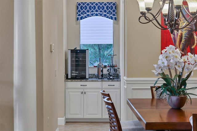 bar with white cabinetry and light tile patterned floors