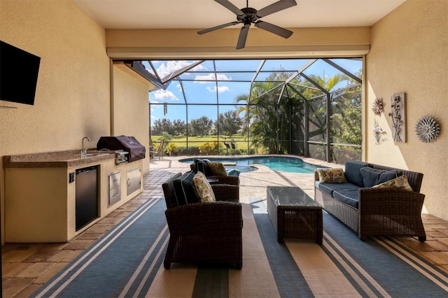 view of patio with an outdoor kitchen, ceiling fan, a lanai, outdoor lounge area, and a grill