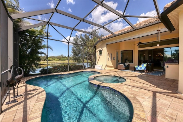 view of swimming pool with an in ground hot tub, a patio area, a water view, glass enclosure, and ceiling fan