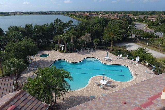 view of swimming pool with a patio area and a water view