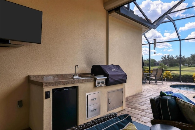 view of patio / terrace featuring a pool, area for grilling, exterior kitchen, sink, and a lanai