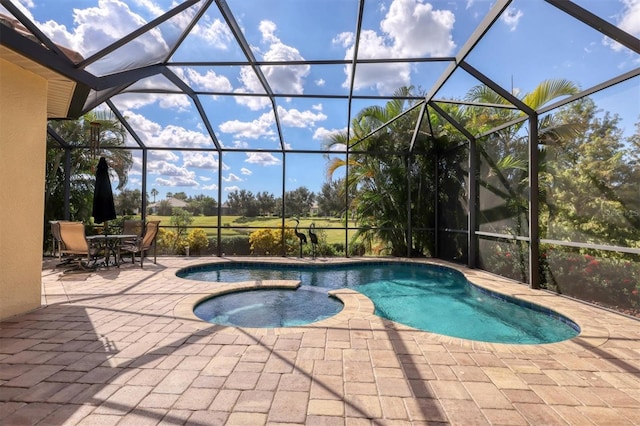 view of pool featuring a patio area, an in ground hot tub, and glass enclosure