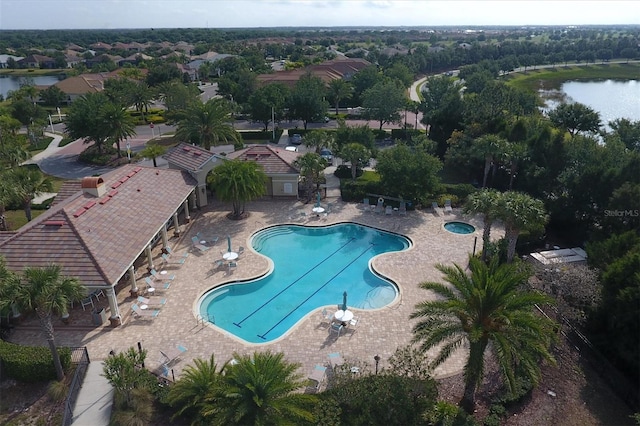 view of pool featuring a water view and a patio area