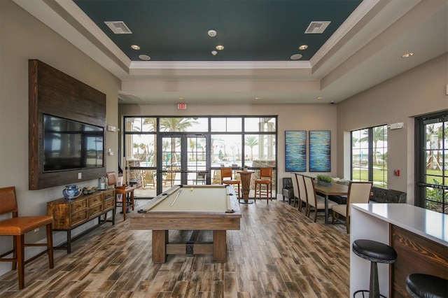 game room featuring hardwood / wood-style floors, crown molding, and a tray ceiling