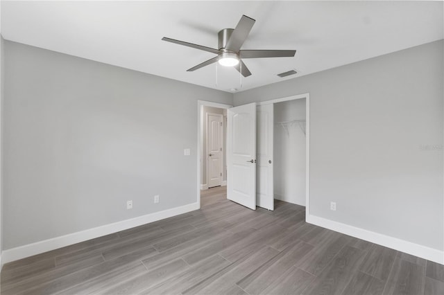 unfurnished bedroom with ceiling fan, a closet, and dark wood-type flooring