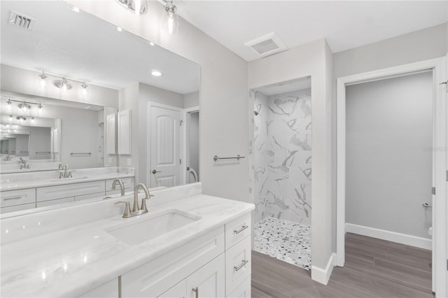 bathroom with tiled shower and oversized vanity