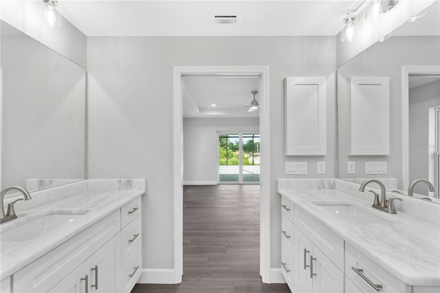 bathroom with double vanity, ceiling fan, and hardwood / wood-style floors