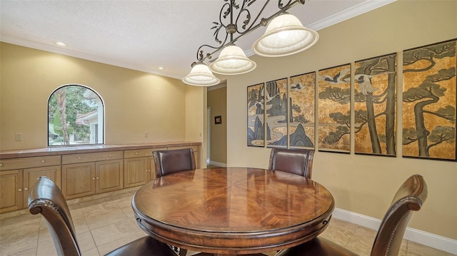 dining room featuring ornamental molding, a textured ceiling, and light tile patterned floors