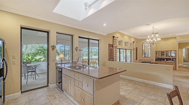 kitchen with hanging light fixtures, sink, a skylight, light brown cabinetry, and appliances with stainless steel finishes