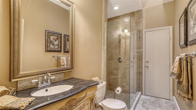 bathroom featuring vanity, toilet, and walk in shower