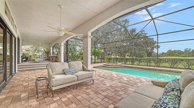 view of pool with an in ground hot tub, a lanai, outdoor lounge area, ceiling fan, and a patio