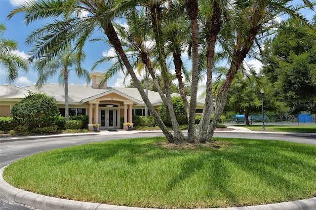 view of front of home with french doors and a front lawn