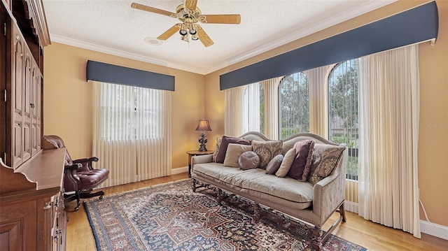 sitting room with a textured ceiling, light hardwood / wood-style flooring, ceiling fan, and a healthy amount of sunlight