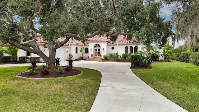 mediterranean / spanish home featuring a front lawn