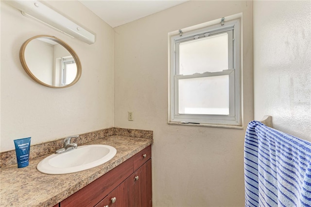 bathroom featuring a healthy amount of sunlight and vanity with extensive cabinet space