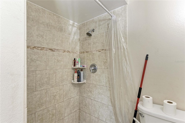 bathroom featuring curtained shower and toilet