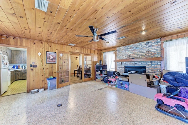 interior space featuring plenty of natural light, wood walls, wood ceiling, and a fireplace