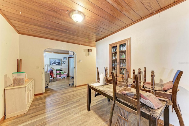 dining room with crown molding, light hardwood / wood-style floors, and wooden ceiling