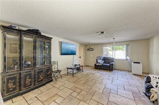 tiled living room featuring a textured ceiling