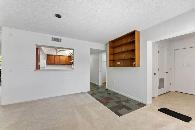 unfurnished room with light colored carpet and ceiling fan