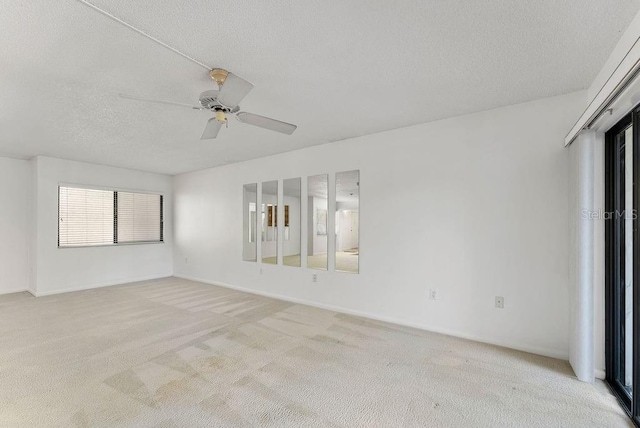 carpeted empty room featuring ceiling fan and a textured ceiling