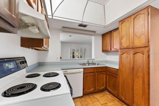 kitchen with white dishwasher, light parquet flooring, extractor fan, range, and sink