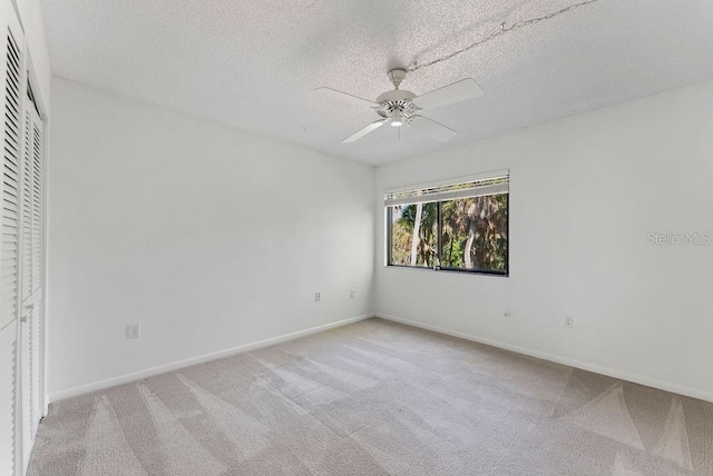 interior space featuring a closet, a textured ceiling, light colored carpet, and ceiling fan