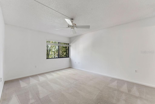 carpeted spare room with a textured ceiling and ceiling fan