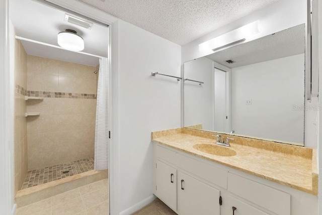 bathroom with a textured ceiling, tile flooring, a shower with shower curtain, and vanity