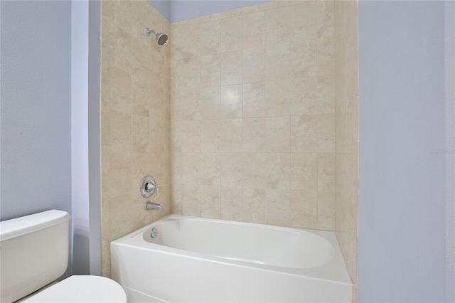 bathroom with tiled shower / bath combo and toilet