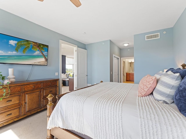 carpeted bedroom with a closet, ensuite bath, and ceiling fan