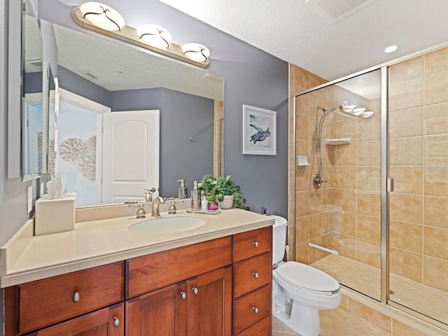 bathroom with tile patterned floors, toilet, vanity, a textured ceiling, and walk in shower