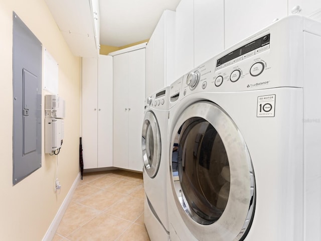 washroom with electric panel, washer and dryer, and light tile patterned floors