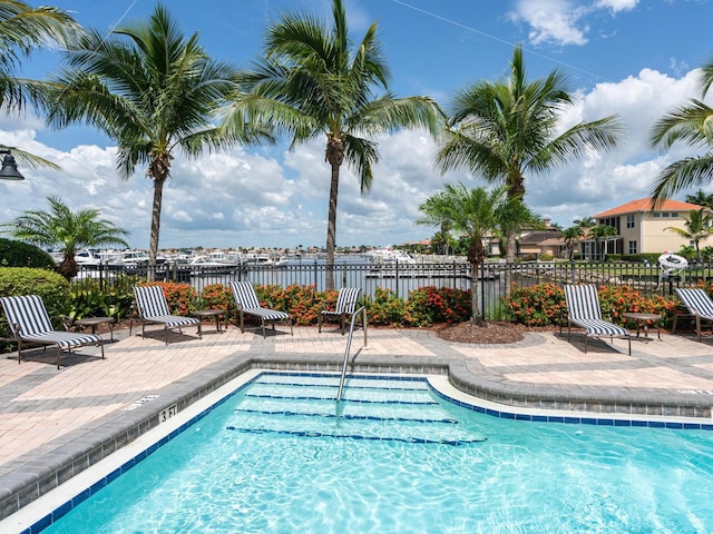 view of pool with a patio area and a water view