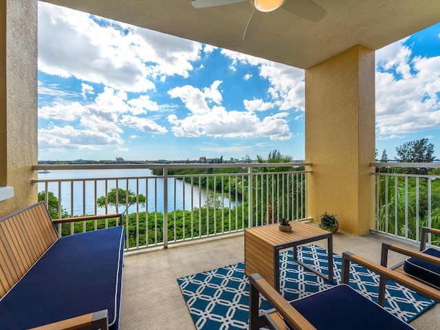 balcony featuring ceiling fan and a water view