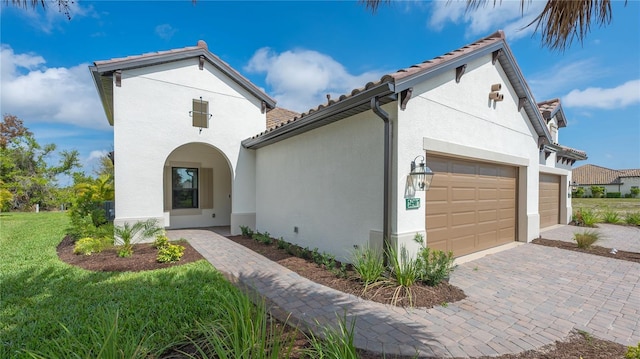 mediterranean / spanish-style home with a garage and a front lawn