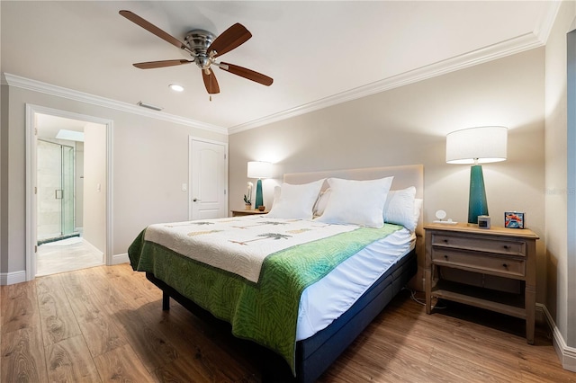 bedroom featuring wood-type flooring, ensuite bath, ceiling fan, and crown molding