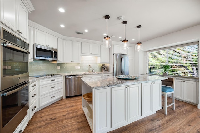 kitchen with white cabinetry, a center island, pendant lighting, and appliances with stainless steel finishes