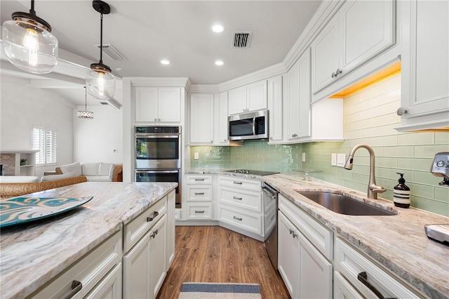 kitchen featuring hanging light fixtures, white cabinetry, sink, and stainless steel appliances