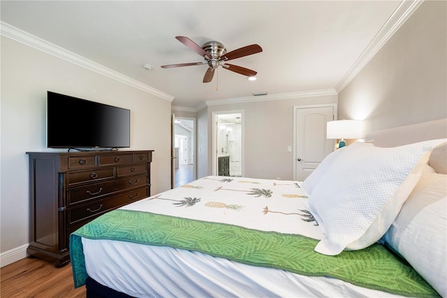 bedroom featuring ceiling fan, wood-type flooring, crown molding, and ensuite bath