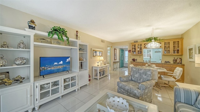 living room featuring sink, a textured ceiling, and light tile flooring