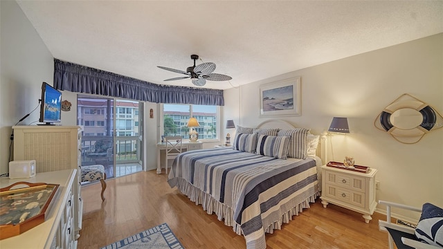 bedroom with a textured ceiling, ceiling fan, and light hardwood / wood-style flooring