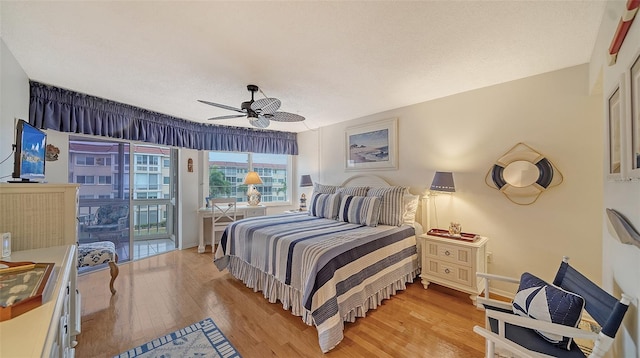 bedroom featuring ceiling fan, light hardwood / wood-style flooring, a textured ceiling, and access to outside