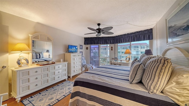 bedroom featuring ceiling fan, dark wood-type flooring, and a textured ceiling