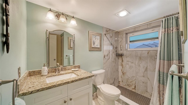 bathroom featuring curtained shower, large vanity, and toilet