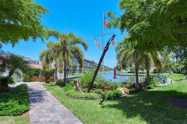 view of property's community with a lawn and a water view