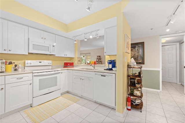 kitchen featuring rail lighting, white appliances, sink, and white cabinets