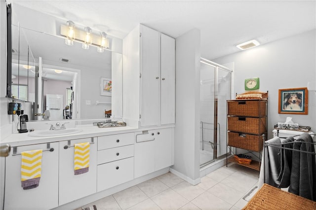 bathroom with vanity, a textured ceiling, a shower with door, and tile patterned floors