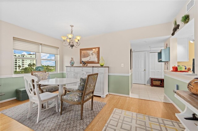 dining area with light wood-type flooring and a chandelier