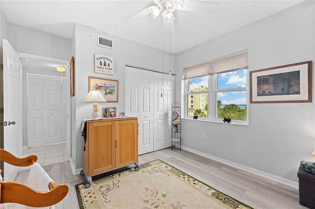 bedroom with a closet, light wood-type flooring, and ceiling fan